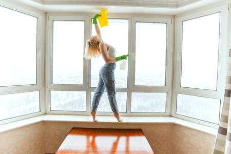 Woman dancer removes an apartment, she washes the windows.の写真素材