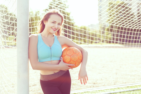 Young woman with a ball at the gate in the stadium.の写真素材