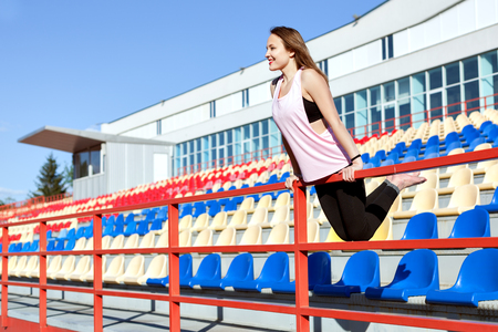 Young woman in sportswear standing on the stadium podium.の写真素材
