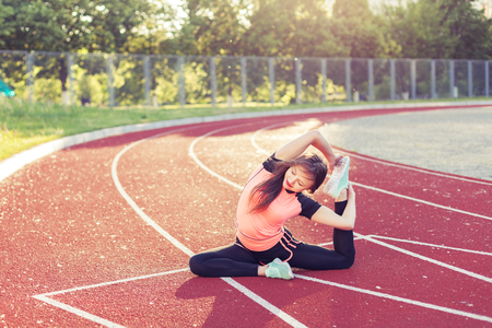 Athletic woman warming up before the race it at the stadium.の写真素材