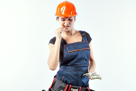 Young woman holds money in her hands, she bites the bitcoin with her teeth.の写真素材