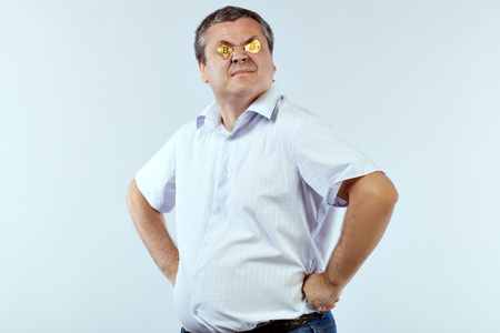 Portrait of a businessman with gold coins of bitcoin.の写真素材
