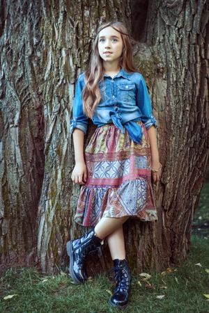 Beautiful girl dressed in boho style standing at tree.の写真素材