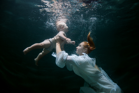Mother teaches the baby to dive underwater.の写真素材