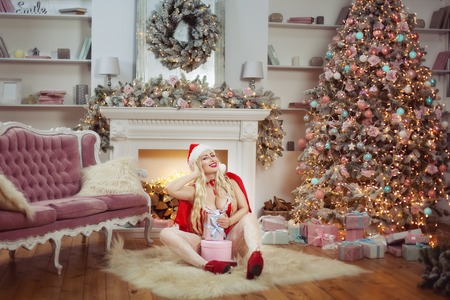 Joyful woman with gifts under the Christmas tree.の写真素材