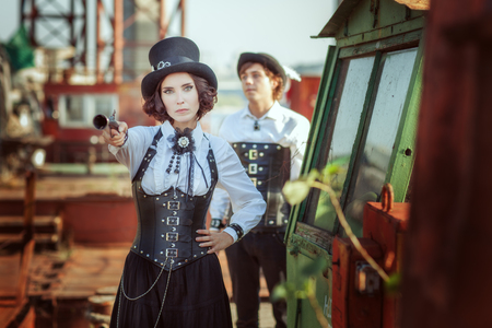 Beautiful woman with a gun in his hand, behind her man.の写真素材