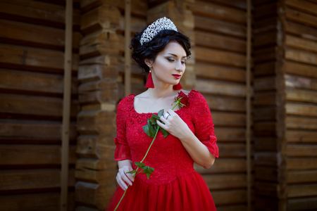 Princess in a red dress, in her hands a rose flower.の写真素材