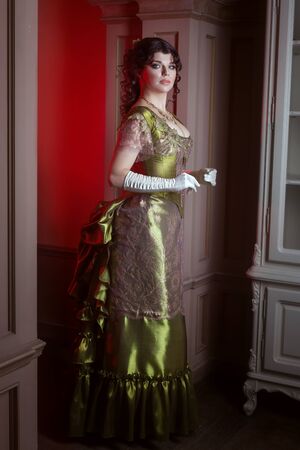Woman in retro style, her beautiful dress is olive color.の写真素材