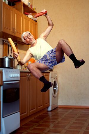 Comic levitation of an old man in the kitchen. His sleep with food.の写真素材