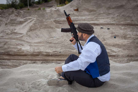 A  soldier monitors a road in Afghanistan. A soldier stands on guard with a weapon to kill.の写真素材