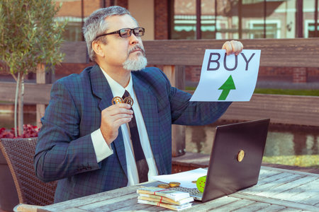 Man pumps a financial bubble with a pump. Computer bitcoins and cash currency.の写真素材