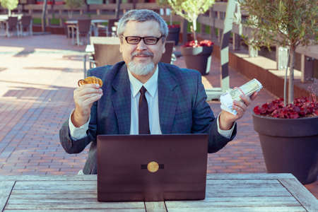 Male businessman trader shows stop with his hand and demonstrates bitcoin.の写真素材