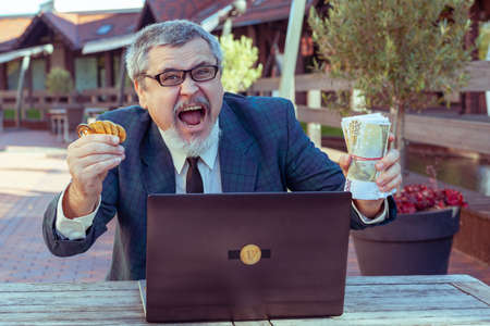 Male businessman trader shows stop with his hand and demonstrates bitcoin.の写真素材