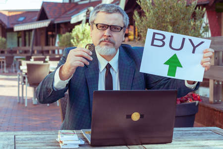 Male businessman trader shows stop with his hand and demonstrates bitcoin.の写真素材