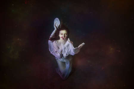 Abstract underwater painting of a girl dressed in a white dress underwater.の写真素材