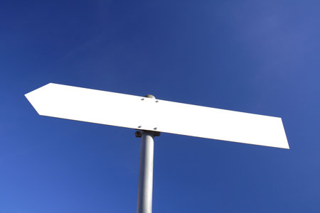 blank white direction board with blue sky in the background