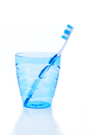 toothbrush in blue plastic glassの写真素材