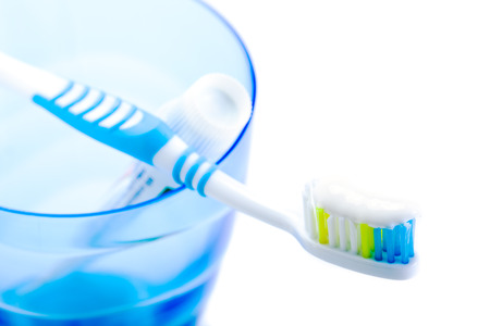 toothbrush and toothpaste in blue plastic glassの写真素材