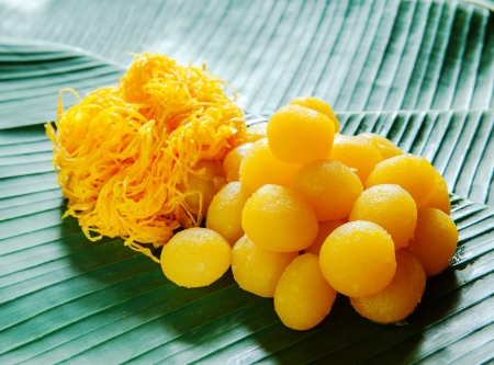 golden Thai dessert on banana leafの写真素材