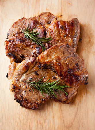 pork chop with rosemary on wooden boardの写真素材