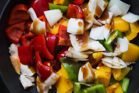 cut bell pepper and onion in pan for cookingの写真素材
