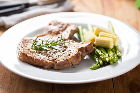 grilled pork chop with vegetable in plateの写真素材