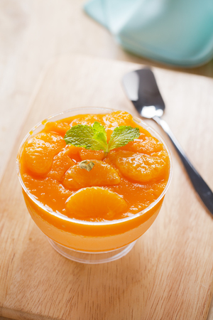 tasty orange cake in cup on wooden boardの写真素材