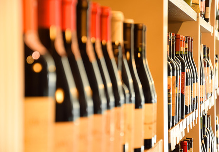 Wine bottles on wooden shelf in wine storeの写真素材