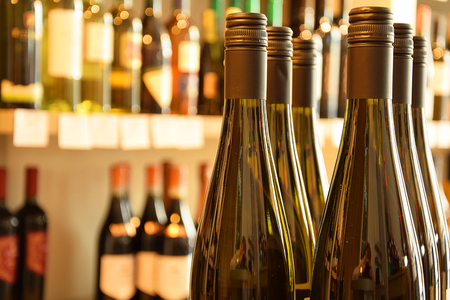 Wine bottles on wooden shelf in wine storeの写真素材