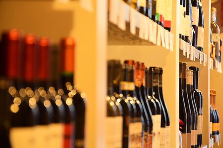 Wine bottles on wooden shelf in wine storeの写真素材