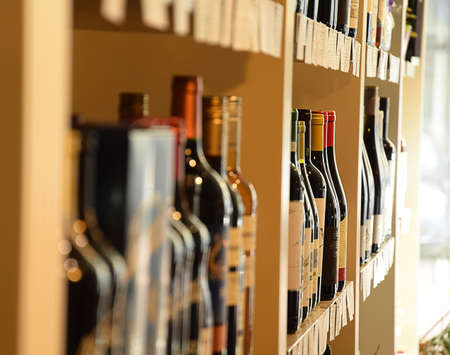 Wine bottles on wooden shelf in wine storeの写真素材