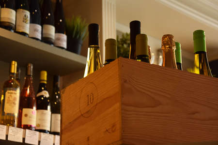 Wine bottles on wooden shelf in wine storeの写真素材