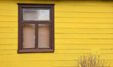 Colored window on a yellow wooden wallの写真素材
