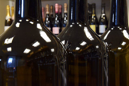 View of rack with wine bottles in a wine shop, restaurant, cafe, bar and close-up of green wine...