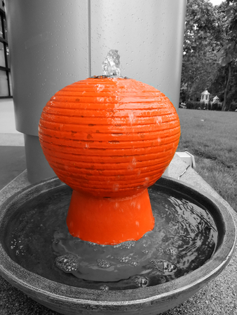 orange Color splash edited of small water fountainの写真素材