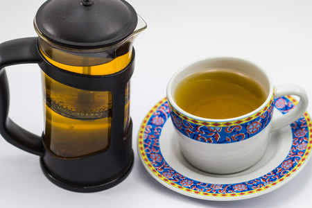 a cup of hot green tea and teapotの写真素材