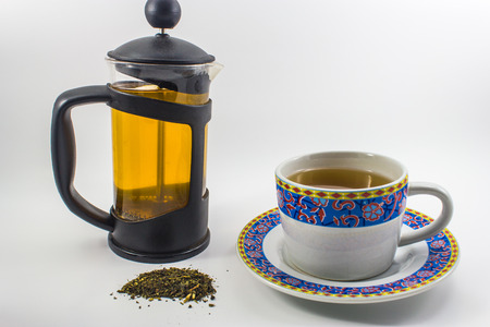 a cup of hot green tea and teapotの写真素材