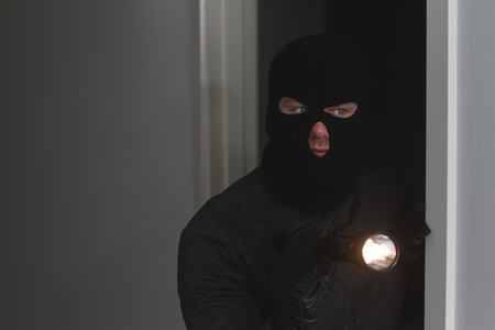 Burglar holding flash lightの写真素材