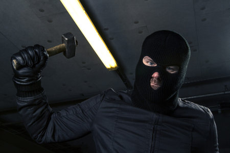 masked criminal with hammer