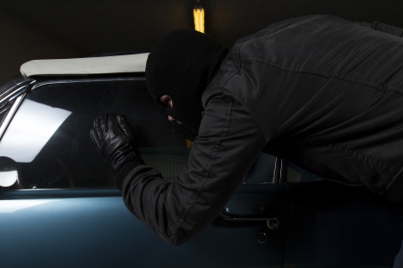 man trying to steal blue carの写真素材