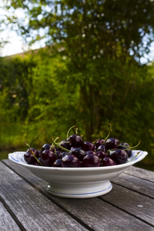 cherries in old porcelain bowlの写真素材