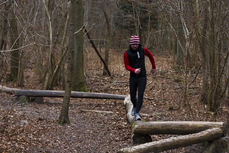 athlete running on wooden hurdles in forestの写真素材