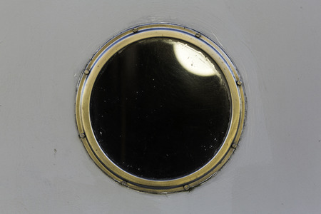 Metal porthole on white boatの写真素材
