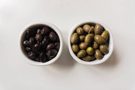 green olives and black olives in white potsの写真素材