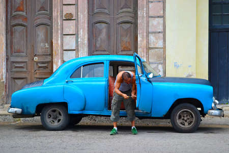 Havana, Cuba - July 8, 2017: A man on the street repairs an old american car in Havana, Cubaのeditorial素材
