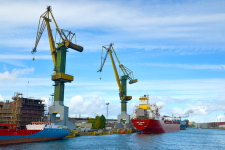Gdansk, Poland - September 28, 2018: Shipyards and docks with cranes and other heavy machinery near...