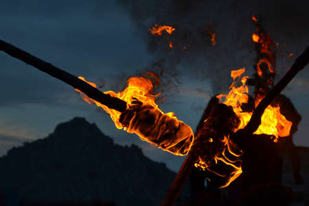 Detail of flames and smoke burning torches. View at dusk, darkness, in the background mountain mountains.の写真素材