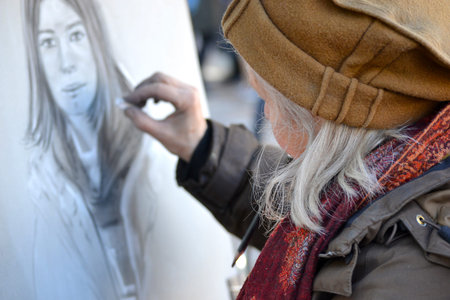 Paris, France - February 16, 2014: Street artist while drawing a painting on Place du Tertre on...
