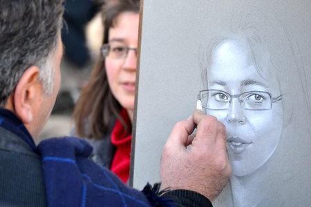 Paris, France - February 16, 2014: Street artist while drawing a painting on Place du Tertre on...