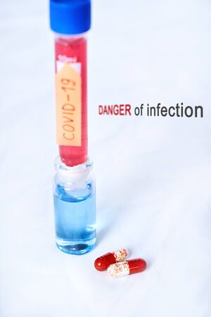 Flasks with red and blue liquid and KOVID-19 coronavirus on a white backgroundの写真素材